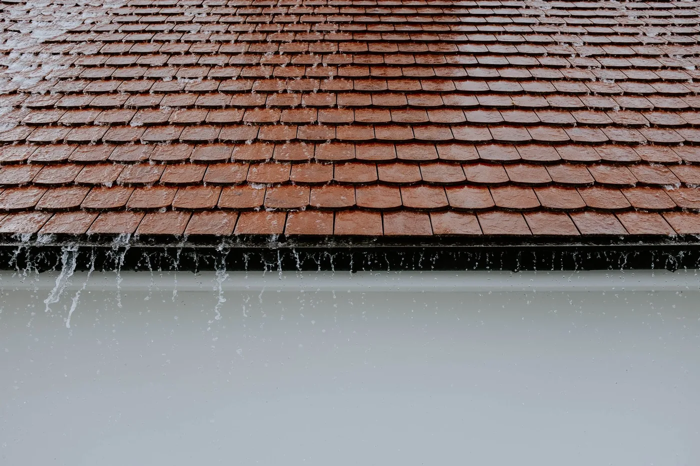 Rain overflowing the edge of a tiled roof
