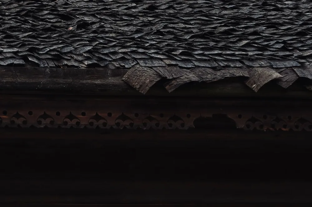 A dark weathered roof surface before treatment