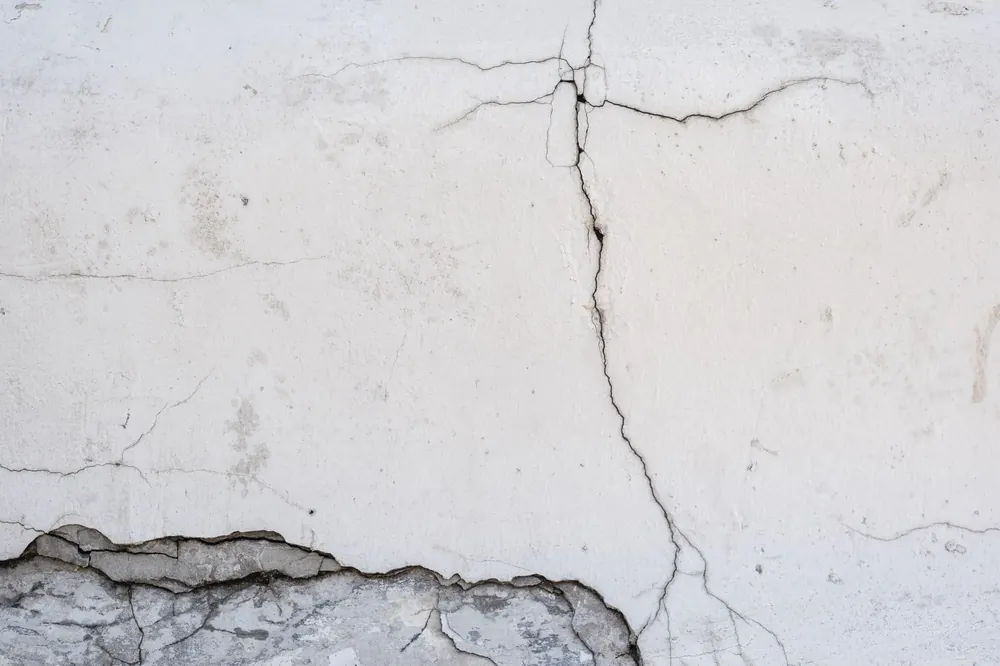 A vertical crack running down a painted basement wall