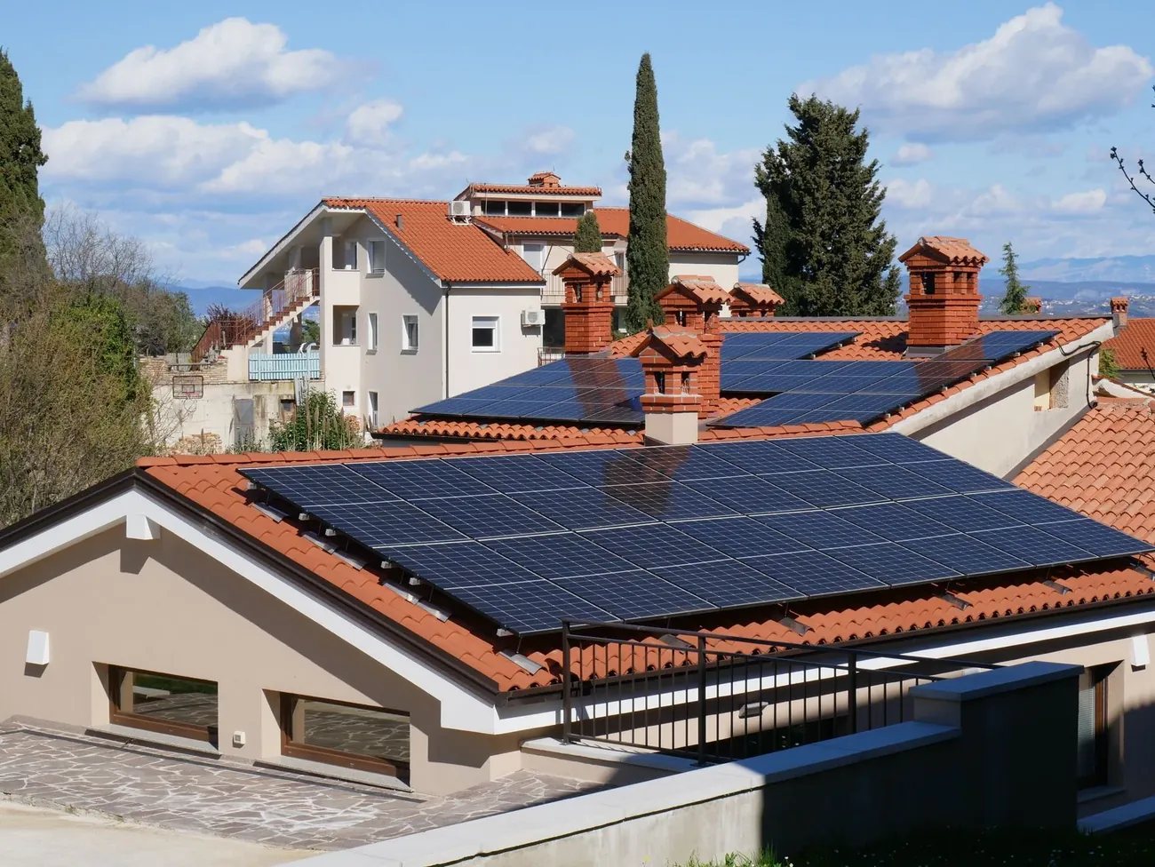 A finished home with solar panels across its tile roof