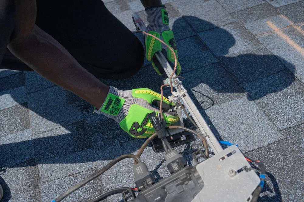 An installer wiring a mounting rail on a roof