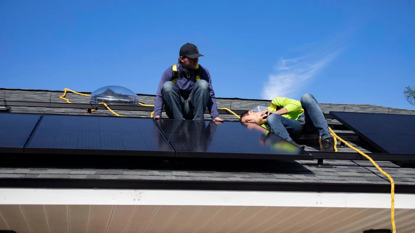Two Solvane installers fixing panels on a sunny roof