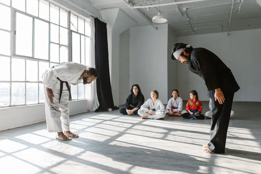 Young children sitting on the mat listening to their instructor