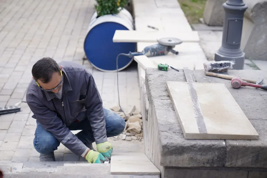 A paver cutting edging stones to fit