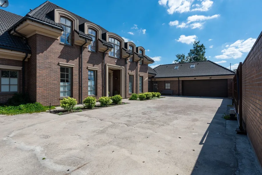 A wide resin bound driveway in front of a brick house