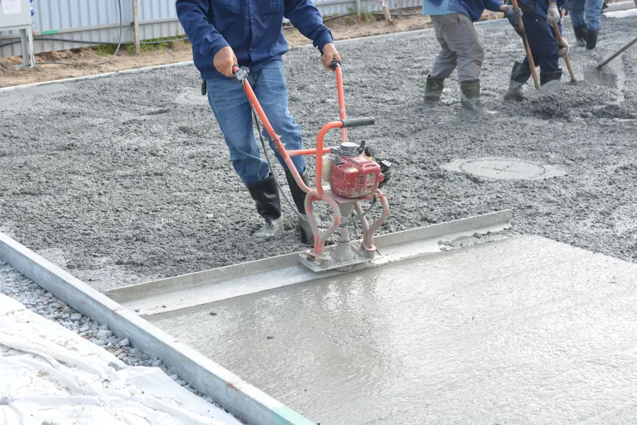A crew compacting the sub base with a plate compactor