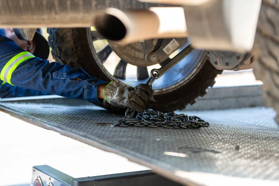 A wheel being chained down on a flatbed deck