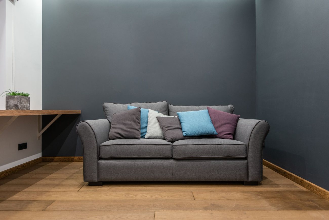 Two cleaners working through a living room