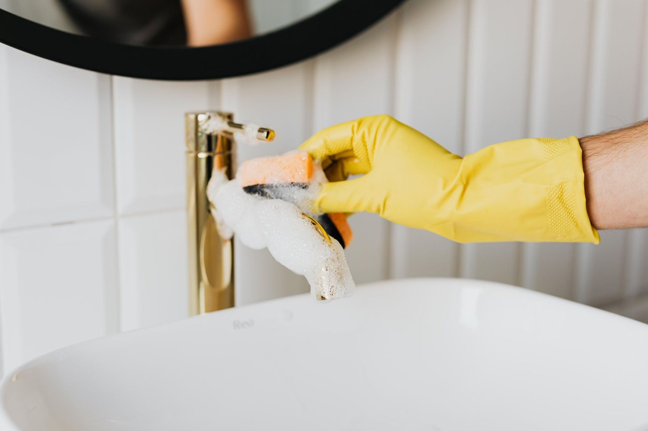 A bathroom basin being cleaned