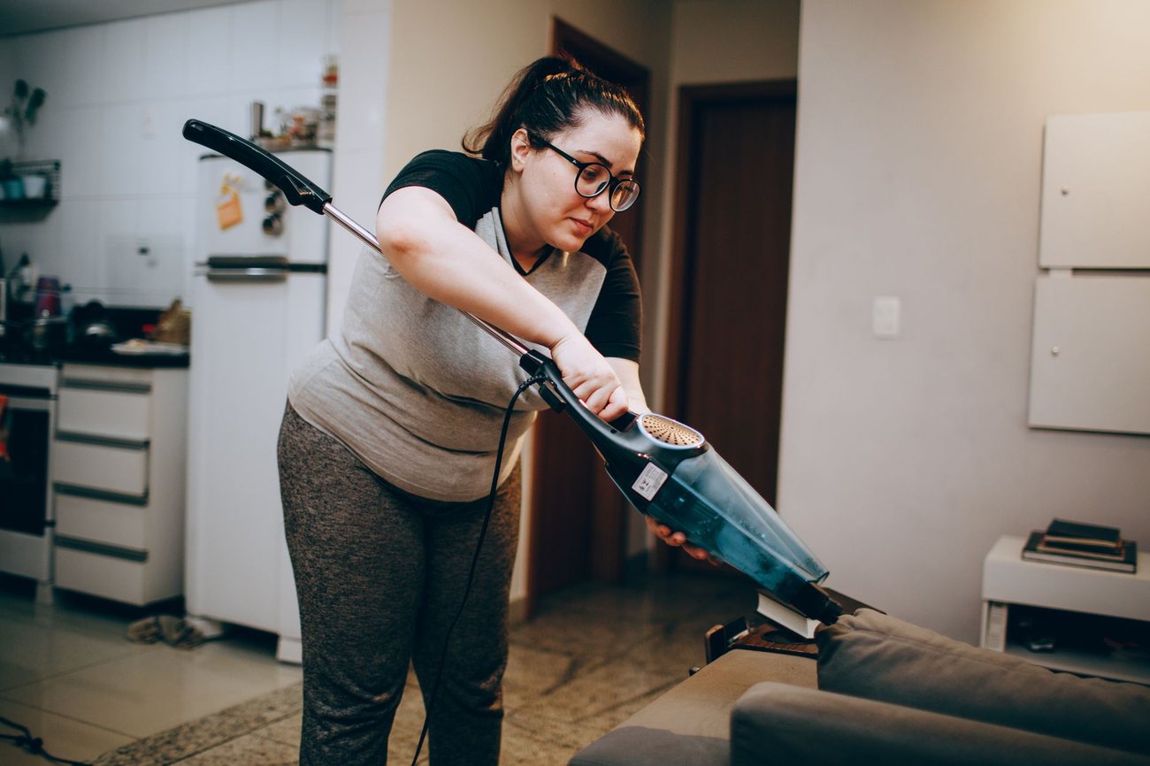 A sofa being vacuumed
