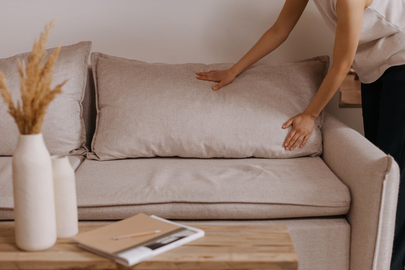 Cushions being straightened on a made sofa