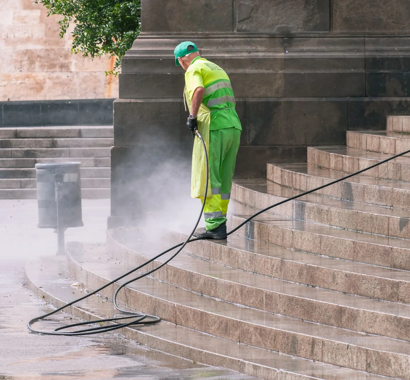 Operator cleaning stone steps with a pressure washer