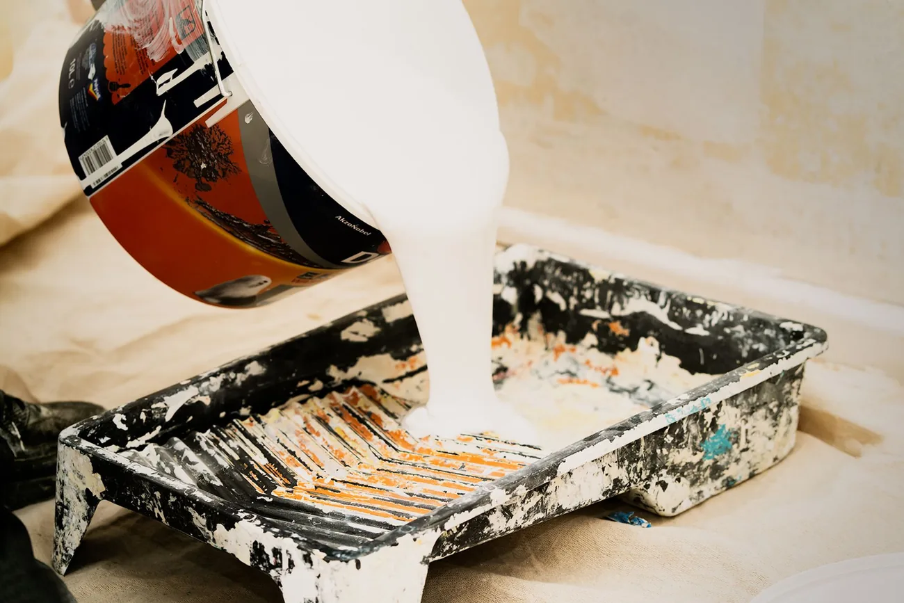 Trade paint being poured into a roller tray