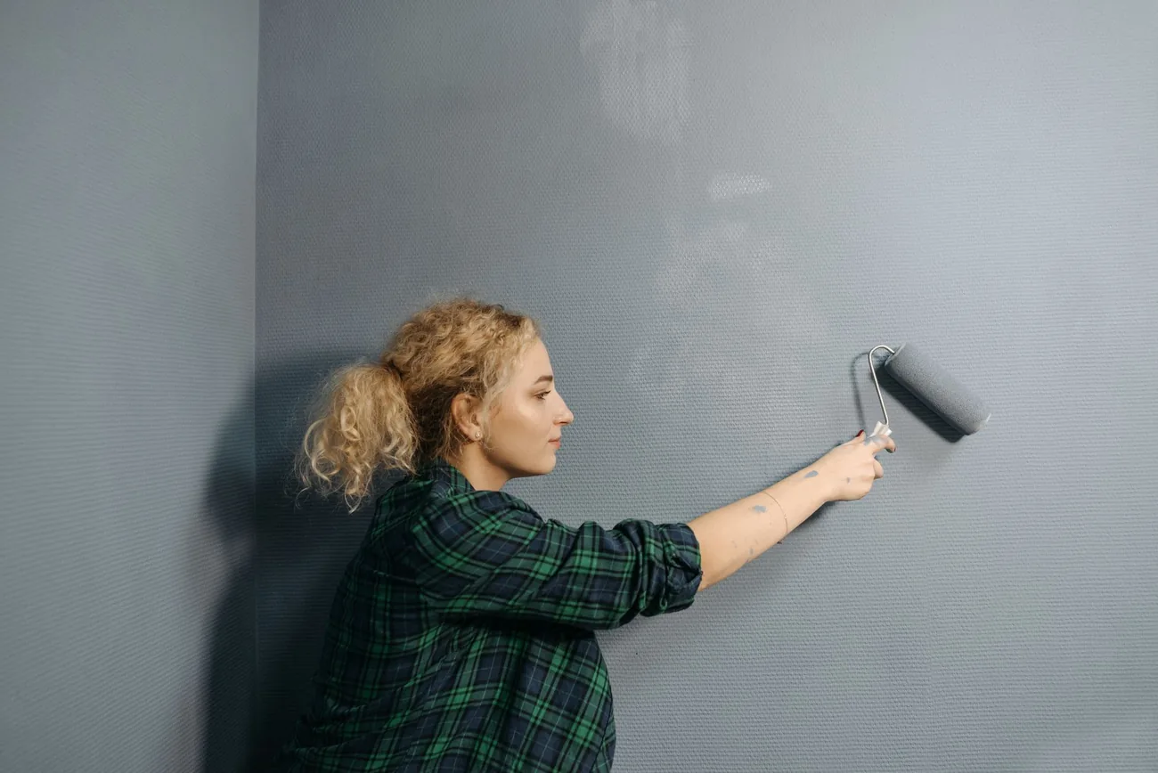 Decorator rolling a wall in a stripped room
