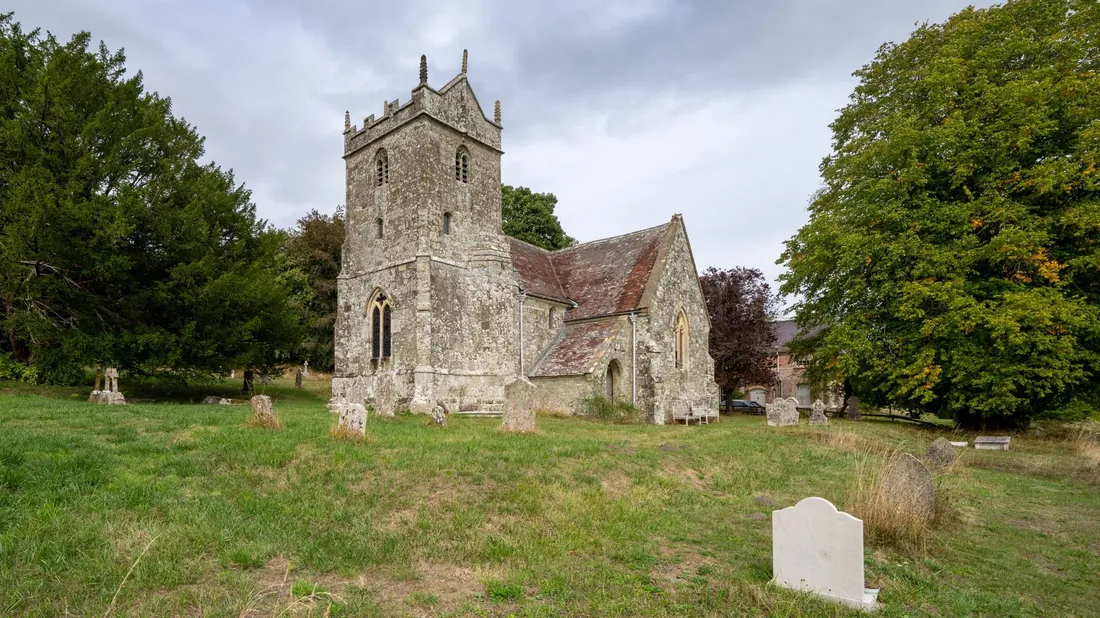 A village church with a square tower among trees